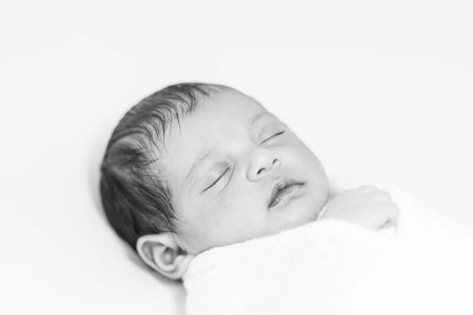 Black and white close-up of a sleeping newborn’s face and eyelashes
